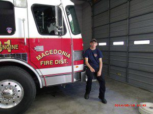 Pictured: RJ sits by a firetruck he hopes to one day drive. He is currently a junior firefighter in Macedonia.