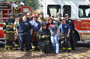 Pictured: Heather McCreery and fiance Bryon Perry, center, with members of Hanahan Firefighters who took part in the house fire proposal.