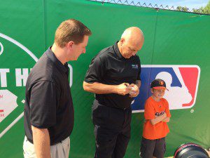 Nine-year-old Kerrick Pruitt scores an autograph from Cal Ripken, as dad Andy looks on.