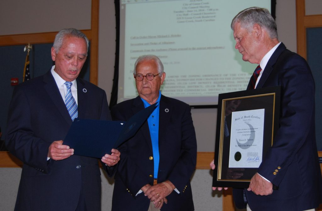 Former Goose Creek City Councilmember and current S.C. Representative Joe Daning (left) reads Gov. Nikki Haley’s letter at the June 14 City Council meeting as Rep. Bill Crosby (center) and Goose Creek City Administrator Dennis Harmon look on.