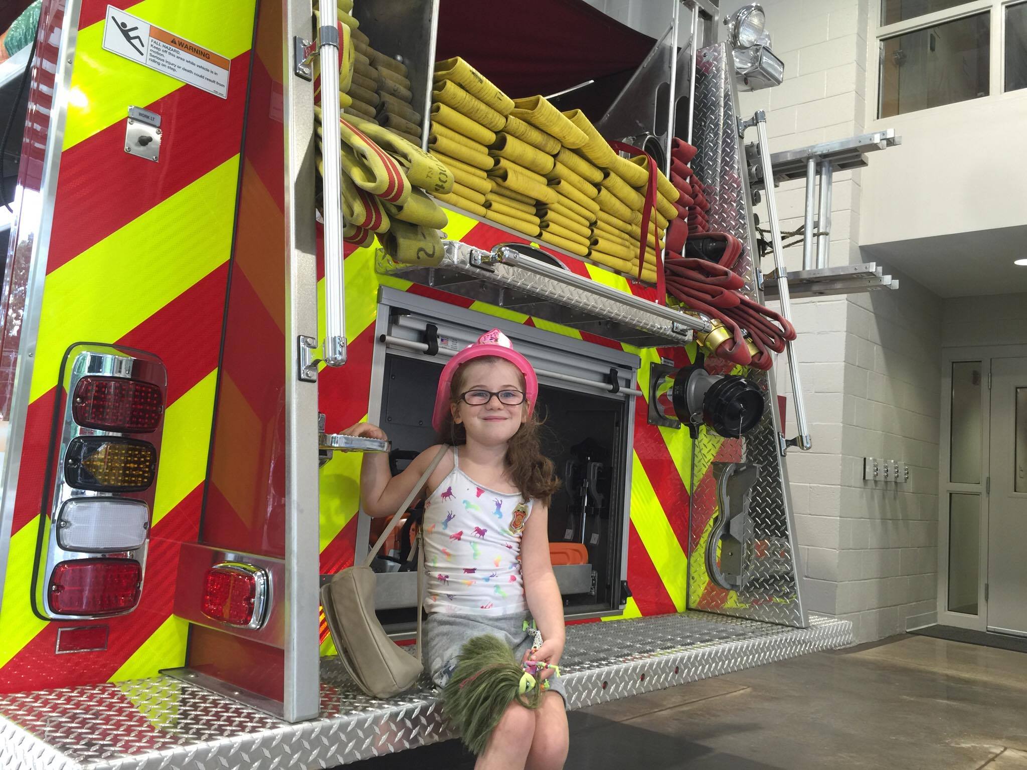Six and a half year old Maddy poses with the fire truck.