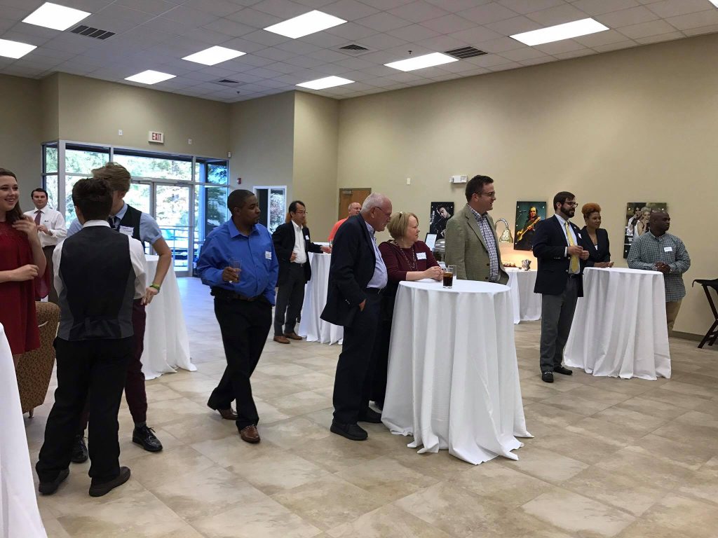 Several attendees enjoys food, beverages, and music at the grand opening of audio-technica.